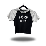 NOBODY CARES WHITE SLEEVE RAGLAN CROP TOP
